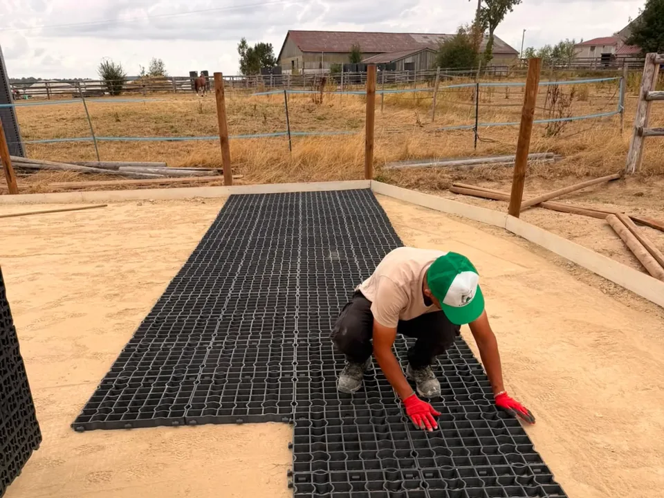 Compagnon emboîtant une dalle à genoux sur la surface en cours de pose