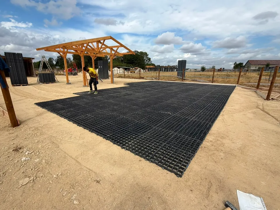 Aire de circulation d'une écurie active stabilisée avec les dalles, devant l'abri en bois